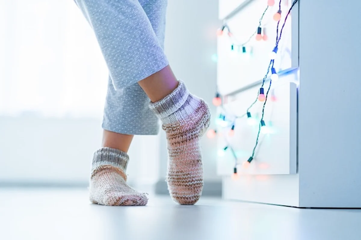 Kobiece nogi w miękkich skarpetach z dzianiny w domu zimą