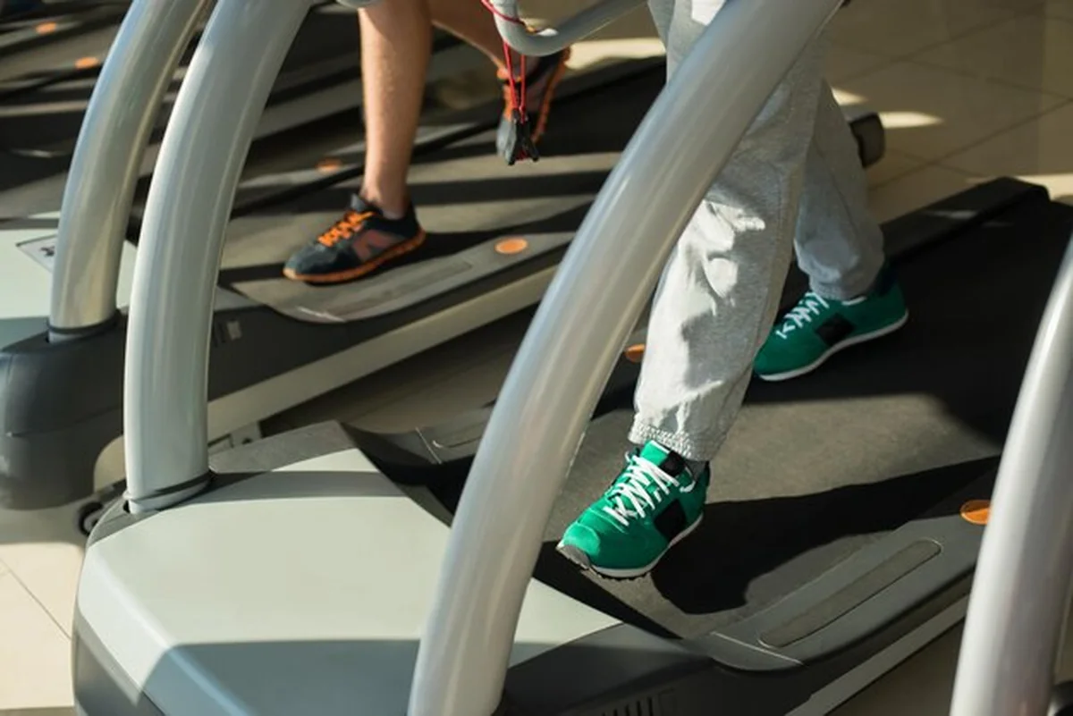 Mężczyźni biegający na bieżni na siłowni